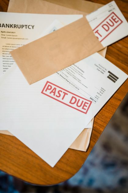 Zdjęcie pokazuje leżace na stole dokuemnty i niezapłacone rachinki co nawiązuje do długó małżonka w czasie rozwod UK.